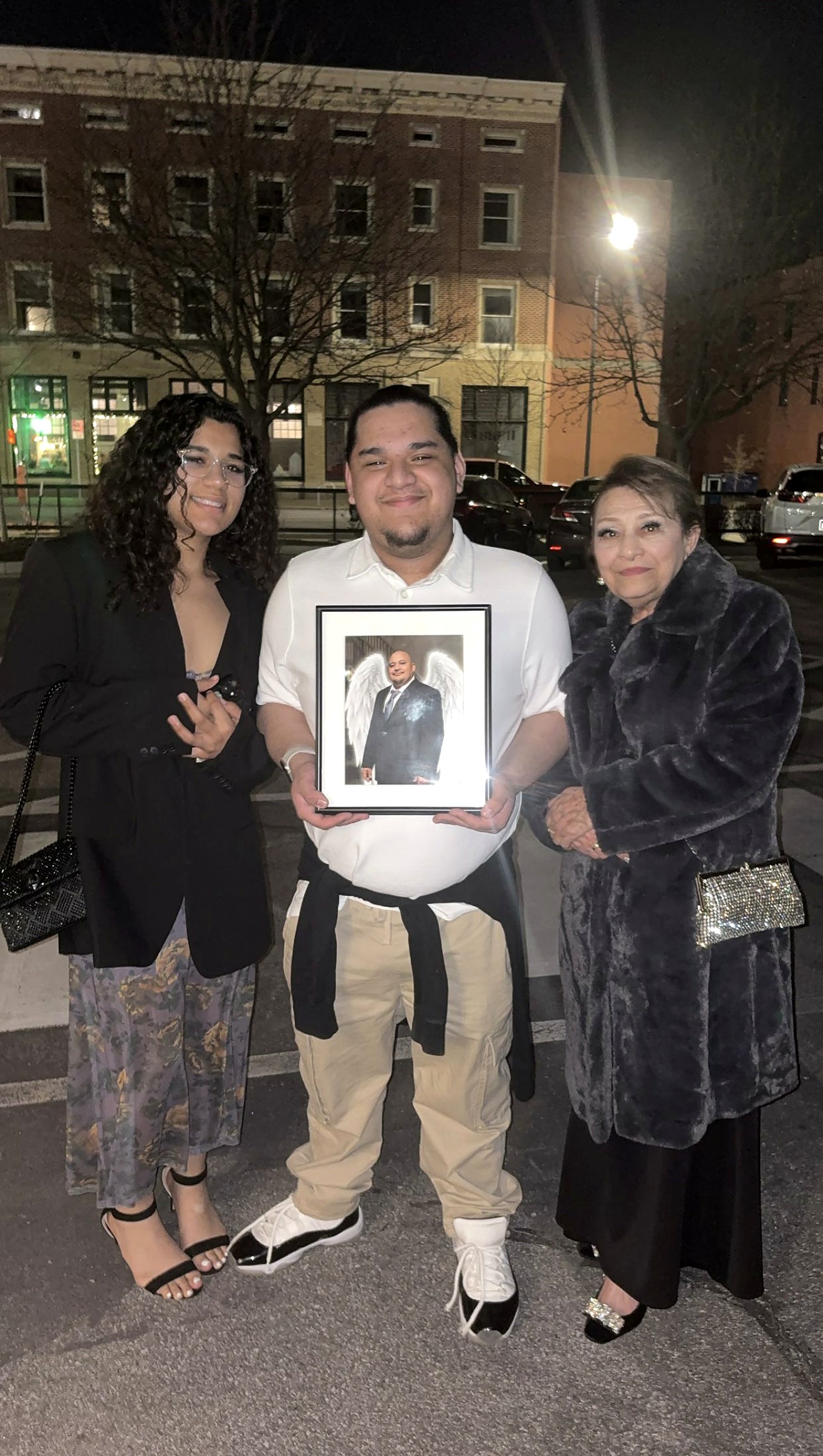 Elvis's family holding a framed portrait of Elvis with angel wings